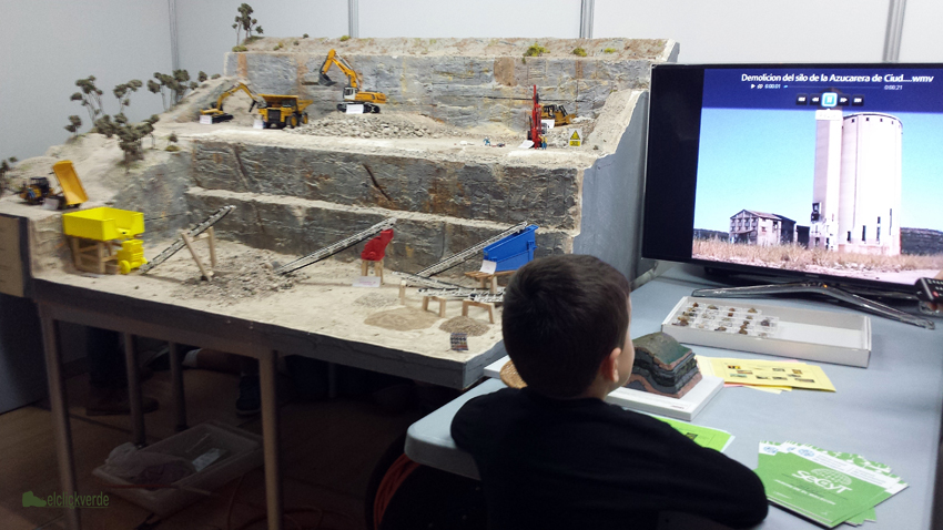 Un niño observa el vídeo de una demolición al lado de la reproducción de una mina elaborada por la UPCT y bien explicada por sus científicos, anoche en la Semana de la Ciencia y la Tecnología de la Región de Murcia. 