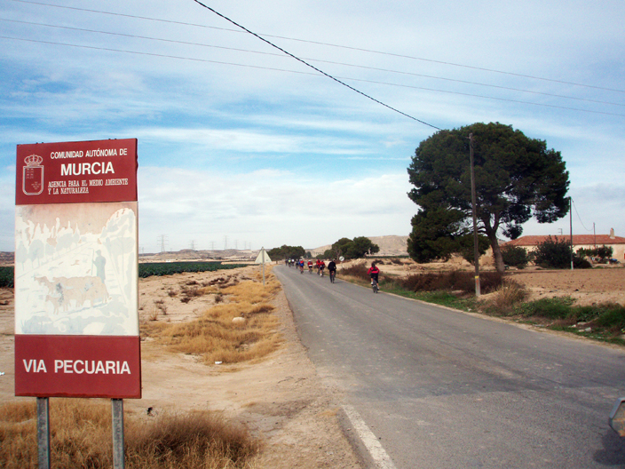 El grupo ciclista cruza el cartel anunciador de la Vereda Real. Imagen: Murciaenbici